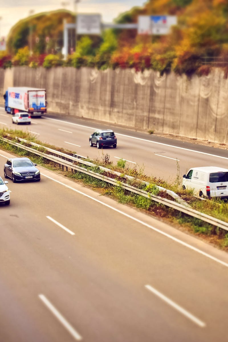 Cars and trucks moving on a highway under sunny skies, showcasing road travel.
